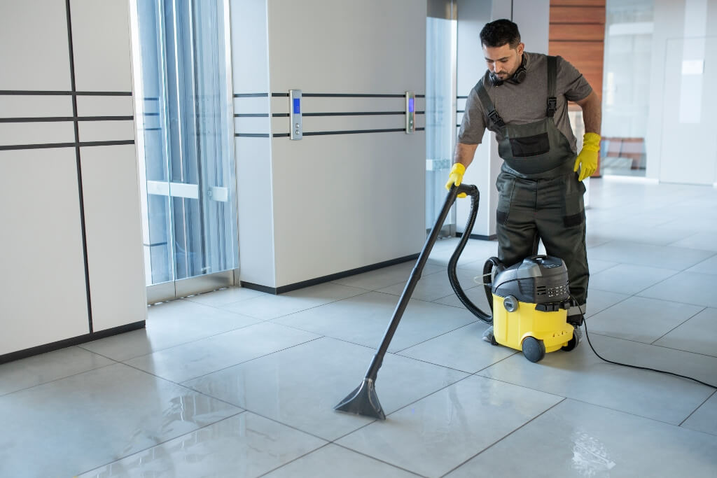 Cleaning-in-London-full-shot-man-vacuuming-office-floor